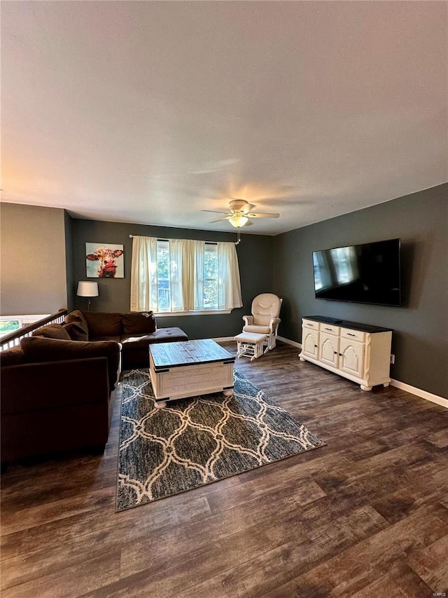 living room with ceiling fan and dark wood-type flooring