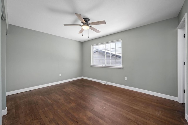 empty room with visible vents, wood finished floors, baseboards, and ceiling fan