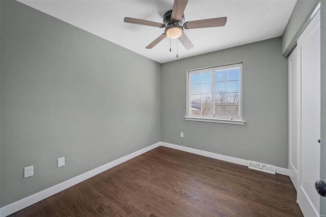 unfurnished bedroom featuring a ceiling fan, baseboards, visible vents, dark wood-style flooring, and a closet