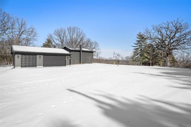 yard layered in snow featuring a garage