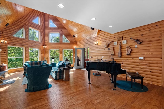 miscellaneous room with high vaulted ceiling, log walls, hardwood / wood-style flooring, wooden ceiling, and a skylight