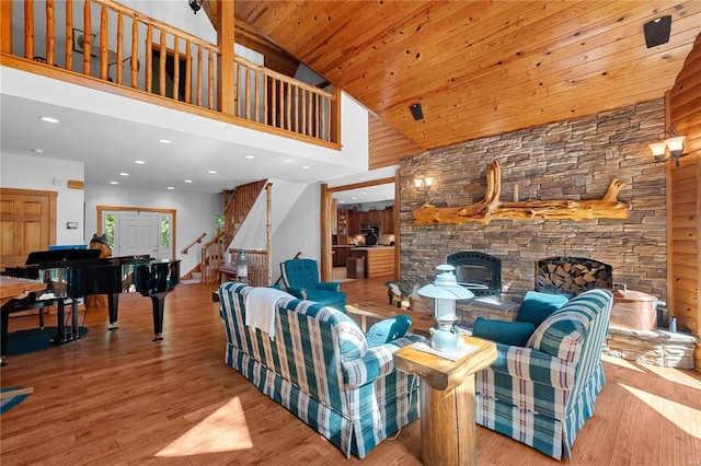 living room with light wood-type flooring, high vaulted ceiling, a fireplace, and wooden ceiling