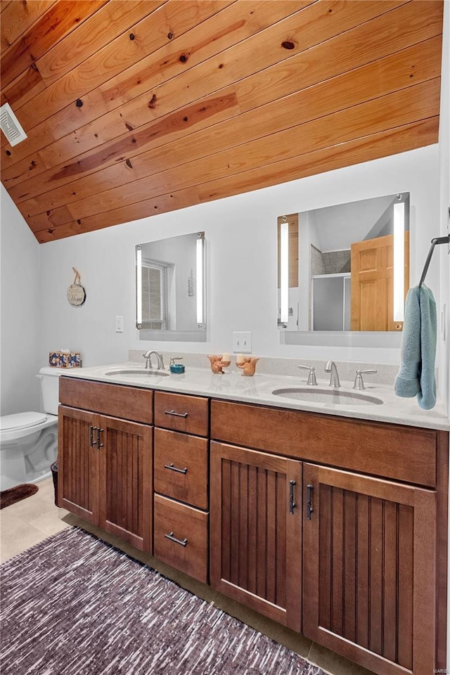 bathroom with vanity, a shower with shower door, toilet, and tile patterned floors