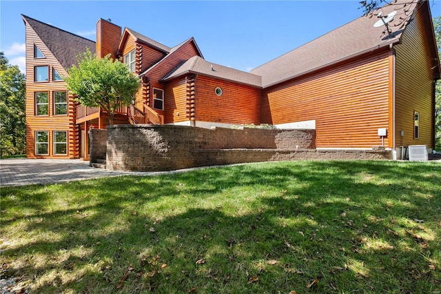 view of side of property with a yard and cooling unit