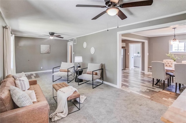 living room with light wood-type flooring, ceiling fan, and washer / clothes dryer