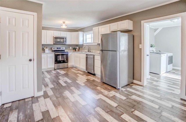 kitchen featuring white cabinets, appliances with stainless steel finishes, light hardwood / wood-style flooring, and sink