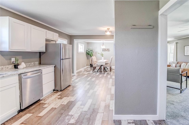 kitchen with light wood-type flooring, light stone countertops, ceiling fan, white cabinets, and appliances with stainless steel finishes