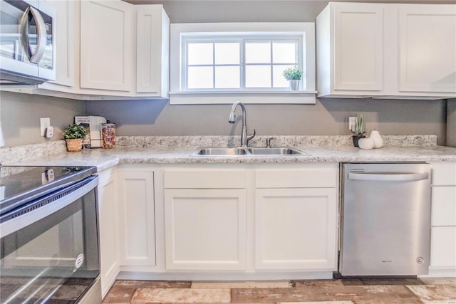 kitchen with stainless steel appliances, sink, and white cabinetry