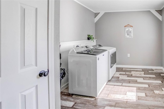 laundry area with washer and dryer and light wood-type flooring