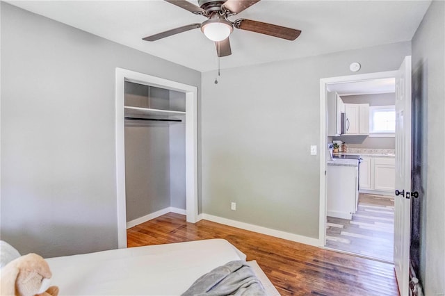 bedroom with ceiling fan, a closet, and light hardwood / wood-style floors