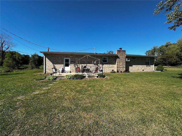 back of house with a lawn and a patio