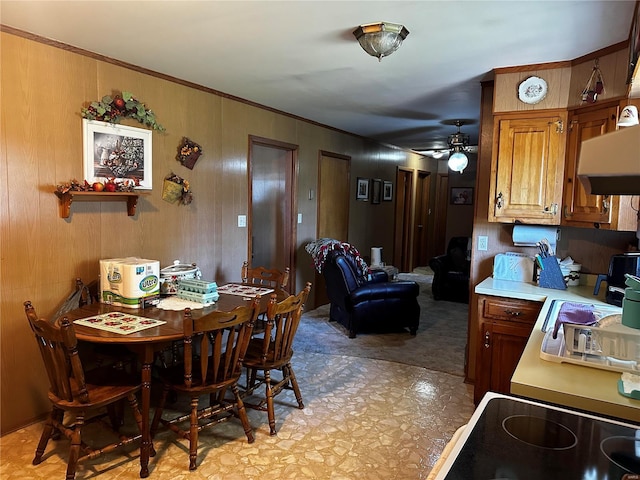 dining area with light floors, a ceiling fan, and crown molding