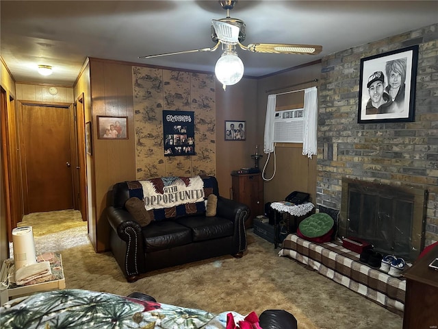 living room with a ceiling fan, carpet, ornamental molding, and a fireplace