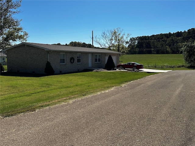 view of front of house with brick siding, a front yard, driveway, and a garage