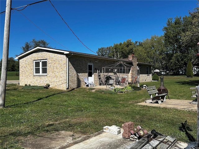 back of house with brick siding, a lawn, a patio, and a gazebo