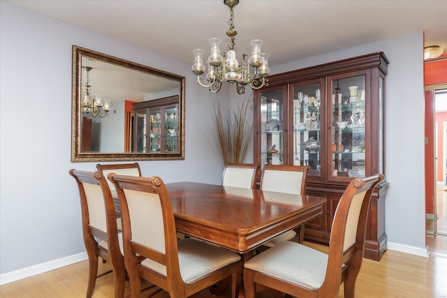 dining area featuring a notable chandelier and light wood-type flooring