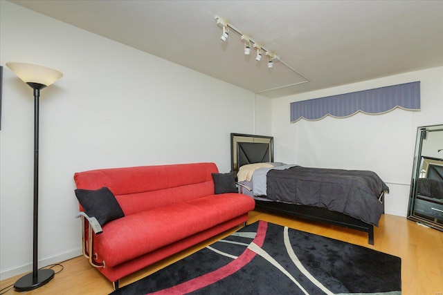 bedroom with hardwood / wood-style flooring and rail lighting