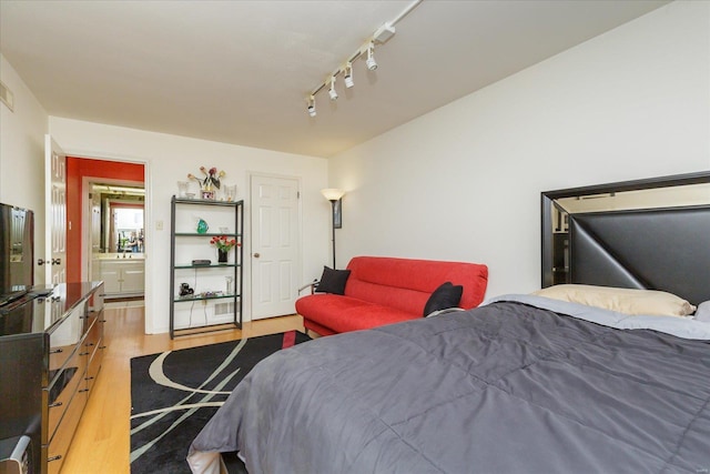 bedroom featuring track lighting and light wood-type flooring