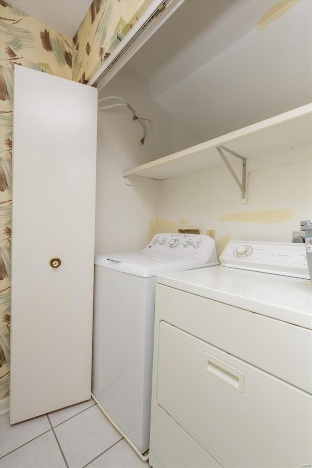 laundry room with independent washer and dryer and light tile patterned flooring