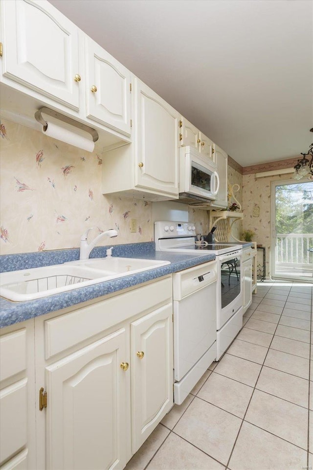 kitchen with sink, white appliances, white cabinetry, and light tile patterned floors