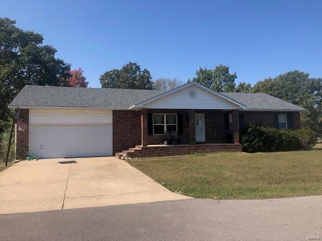 single story home featuring a front yard and a garage