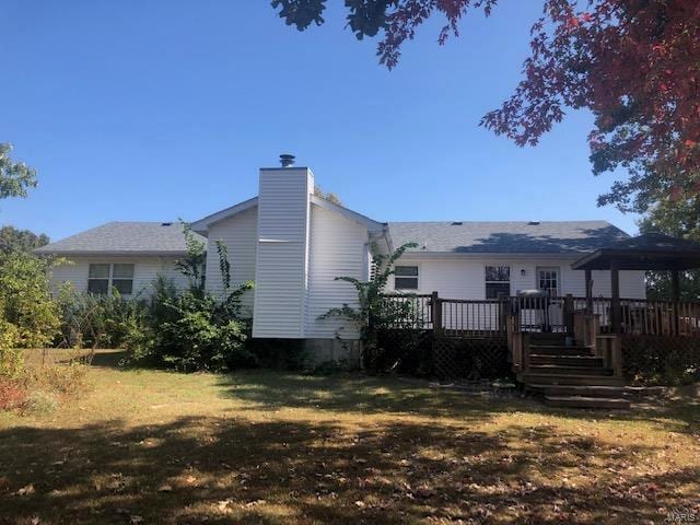 rear view of property with a yard and a deck