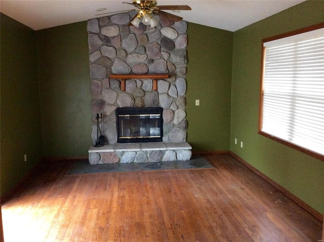 unfurnished living room with ceiling fan, hardwood / wood-style flooring, lofted ceiling, and a fireplace