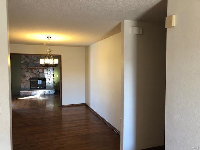 hall featuring a textured ceiling and dark hardwood / wood-style flooring