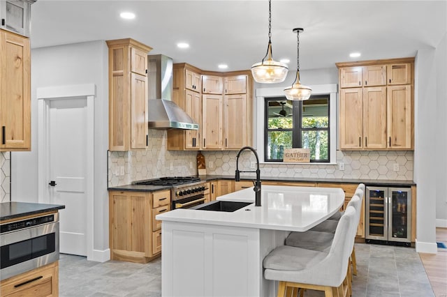 kitchen featuring sink, beverage cooler, wall chimney range hood, stainless steel oven, and light brown cabinetry