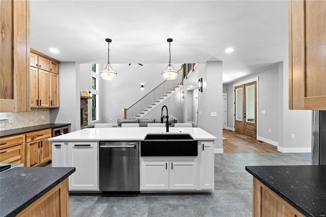 kitchen featuring a wealth of natural light, dishwasher, sink, and white cabinets