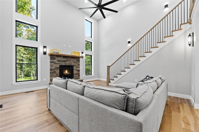 living room with a high ceiling, light hardwood / wood-style flooring, and a wealth of natural light