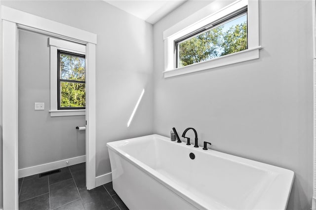 bathroom with tile patterned floors and a tub