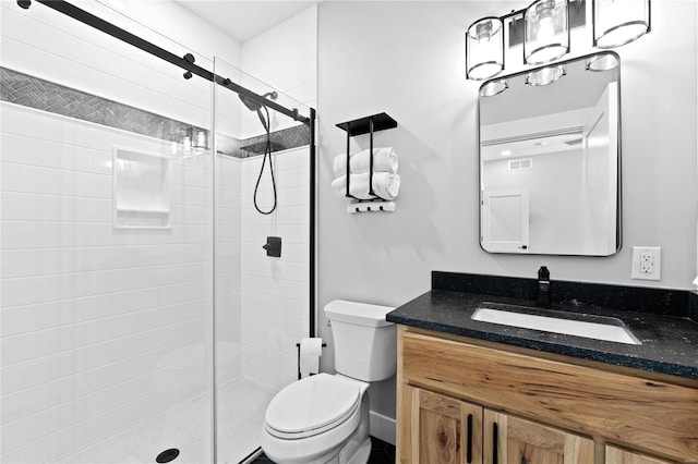 bathroom with toilet, walk in shower, and vanity