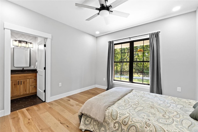 bedroom featuring wood-type flooring, ensuite bath, sink, and ceiling fan