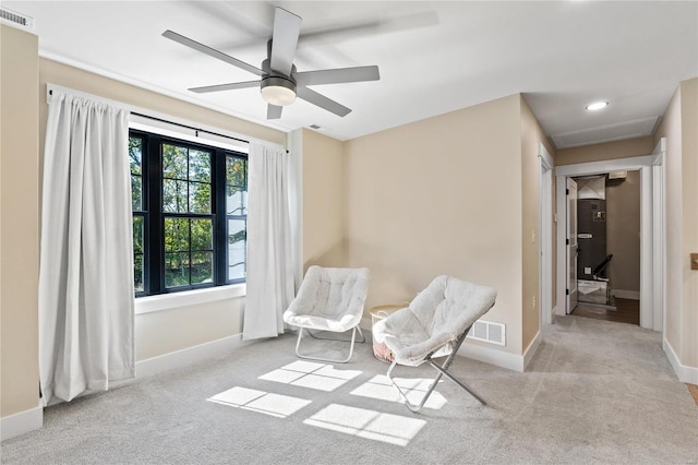 sitting room featuring ceiling fan and light colored carpet