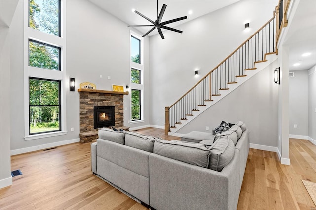 living room featuring a high ceiling, plenty of natural light, and light hardwood / wood-style flooring