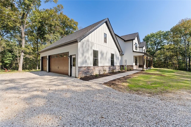 view of side of property featuring a garage and a lawn