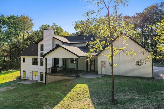 rear view of property featuring a yard and a patio area