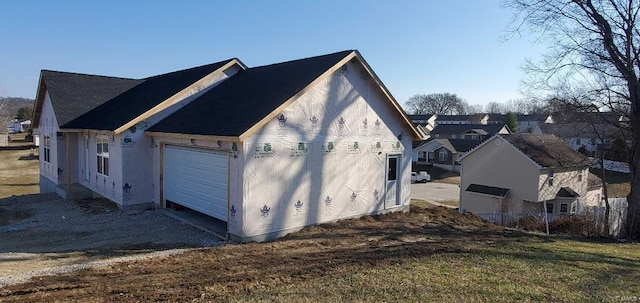 view of side of property featuring driveway and an attached garage