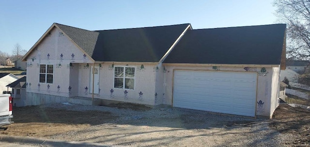 unfinished property with a garage and driveway