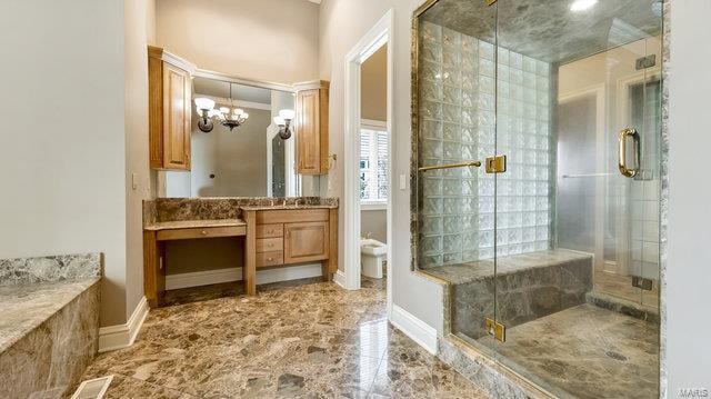 bathroom featuring an inviting chandelier, vanity, toilet, and an enclosed shower