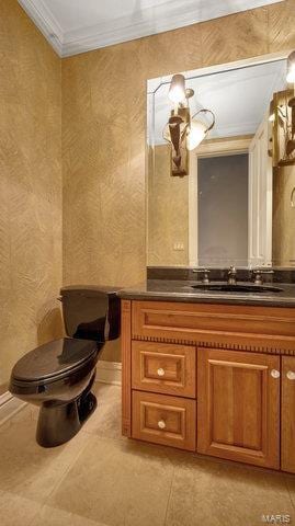 bathroom featuring tile patterned flooring, ornamental molding, vanity, and toilet