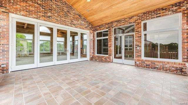 unfurnished sunroom with vaulted ceiling and wooden ceiling