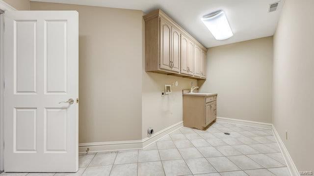 washroom featuring washer hookup, cabinets, light tile patterned floors, and sink