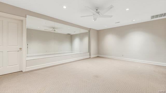 carpeted spare room featuring ceiling fan