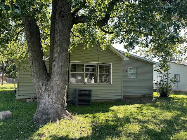 view of home's exterior with a yard and central AC