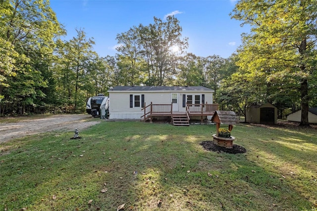 view of front facade with a shed, a front yard, and a deck