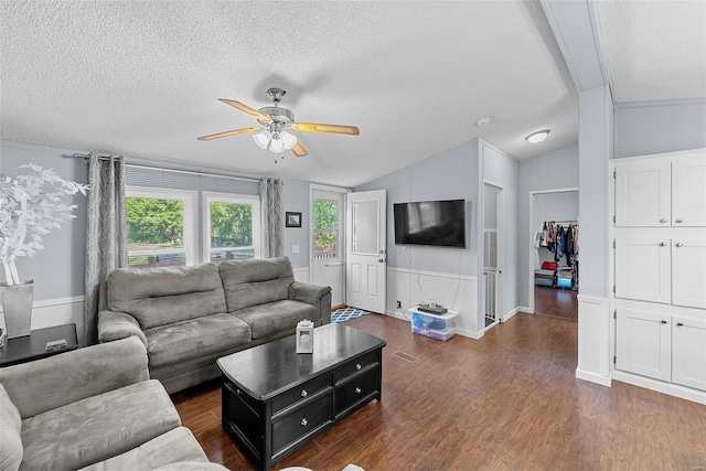 living room featuring ceiling fan, crown molding, dark wood-type flooring, vaulted ceiling, and a textured ceiling