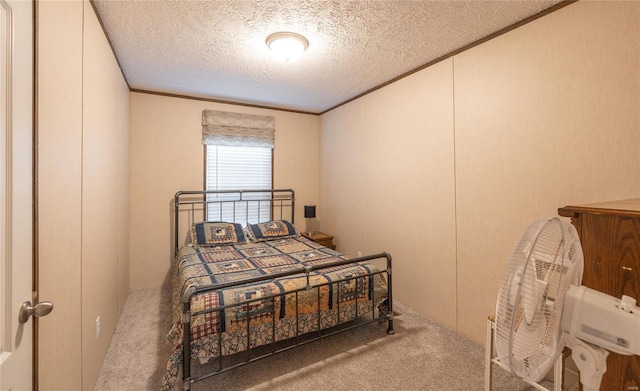 bedroom featuring a textured ceiling, ornamental molding, and carpet flooring