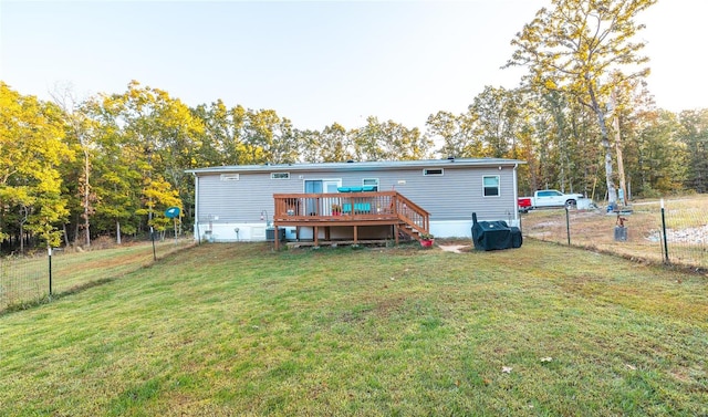 rear view of property featuring a deck and a lawn